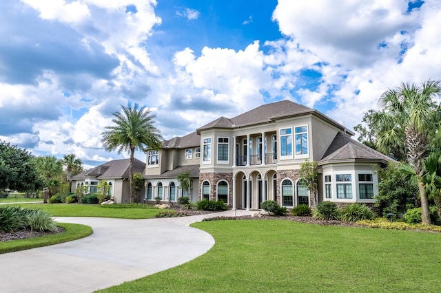 view of front of home featuring a balcony and a front yard