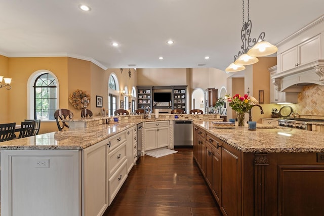 kitchen with a spacious island, a kitchen bar, dark hardwood / wood-style floors, pendant lighting, and stainless steel appliances