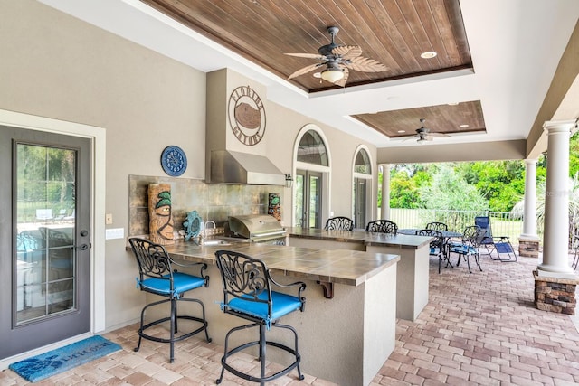 view of patio / terrace featuring an outdoor wet bar, ceiling fan, grilling area, and exterior kitchen