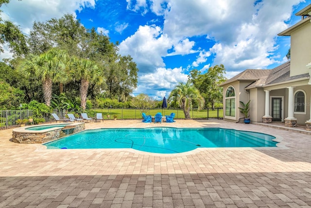 view of swimming pool featuring an in ground hot tub and a patio area