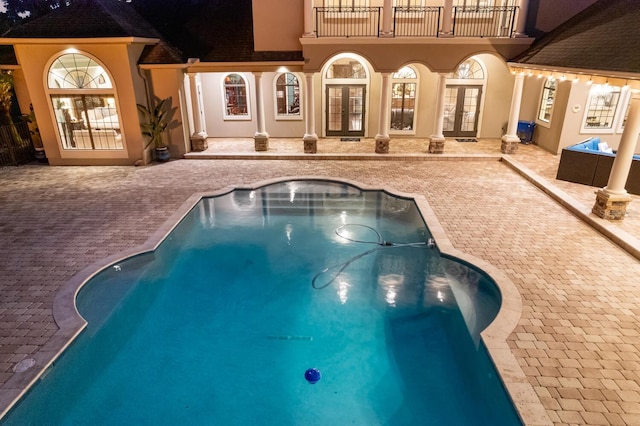 view of pool with french doors and a patio area