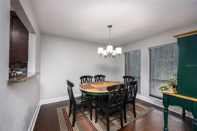 dining space featuring dark hardwood / wood-style flooring and a chandelier