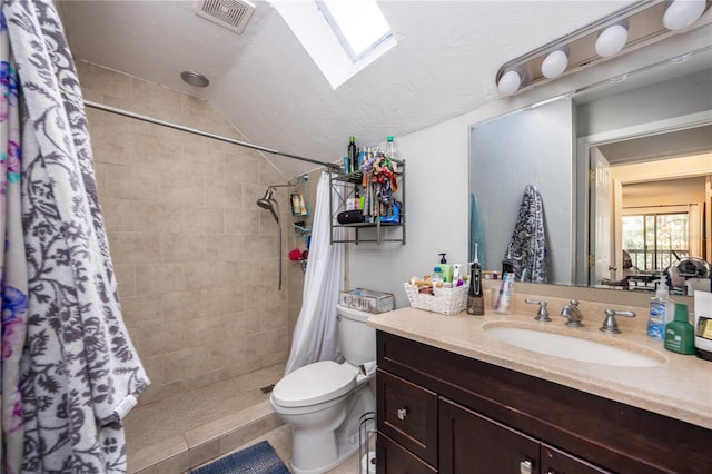 bathroom with toilet, vaulted ceiling with skylight, curtained shower, vanity, and tile patterned floors