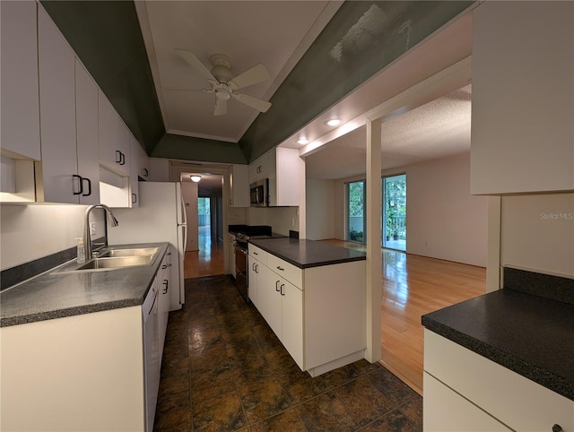 kitchen featuring white cabinets, ceiling fan, black range, dark wood-type flooring, and sink