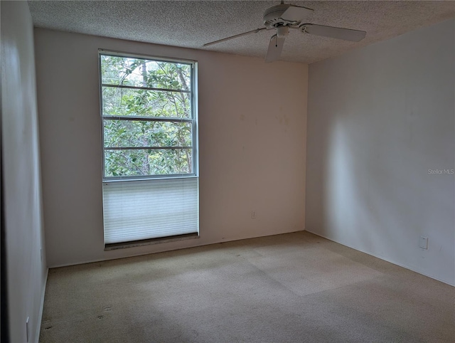 carpeted empty room featuring a textured ceiling and ceiling fan