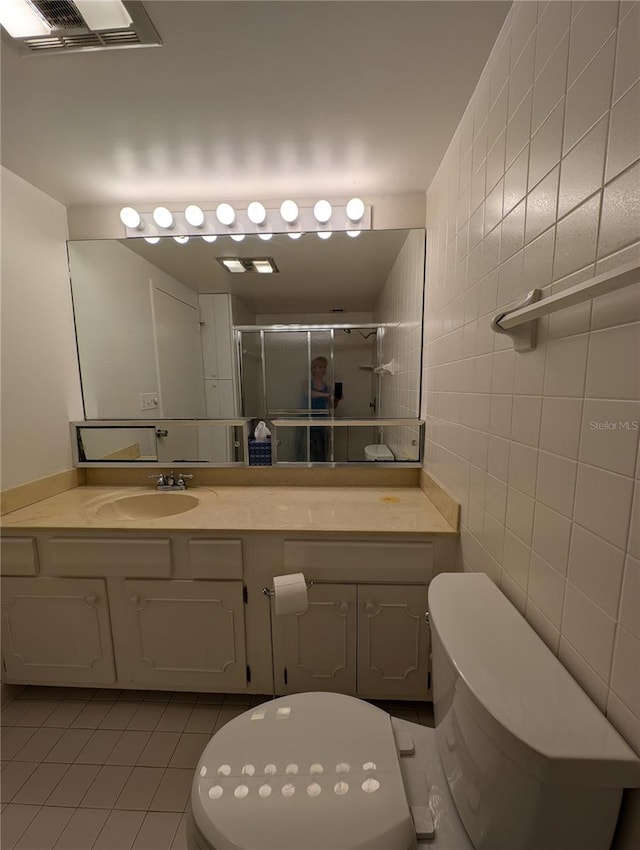 bathroom with vanity, tile patterned flooring, toilet, and walk in shower