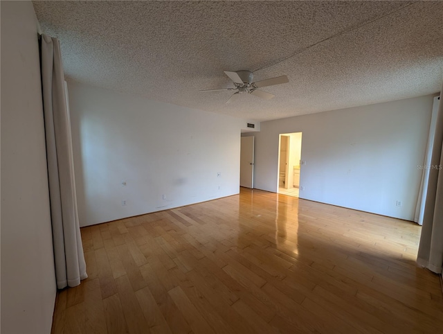 empty room featuring light hardwood / wood-style floors, a textured ceiling, and ceiling fan