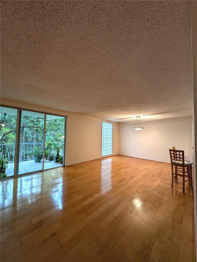 spare room featuring light hardwood / wood-style floors and a textured ceiling