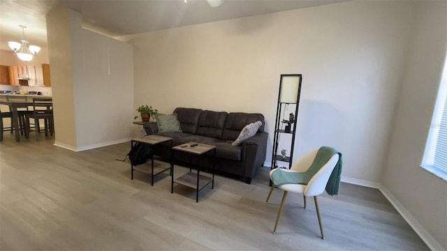 living room with a notable chandelier and light hardwood / wood-style floors