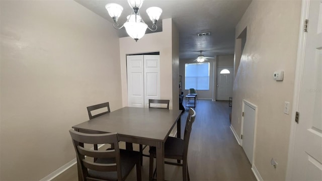 dining area with dark wood-type flooring and ceiling fan with notable chandelier