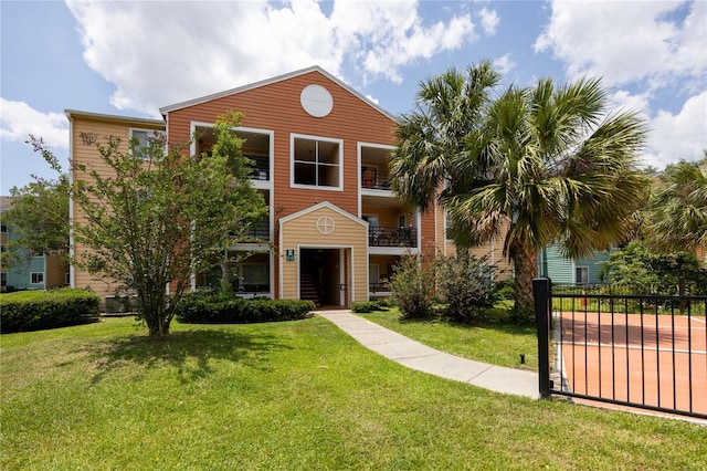 view of front facade with a front yard and a balcony