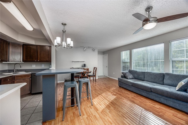 kitchen featuring light hardwood / wood-style floors, a healthy amount of sunlight, sink, and a breakfast bar area