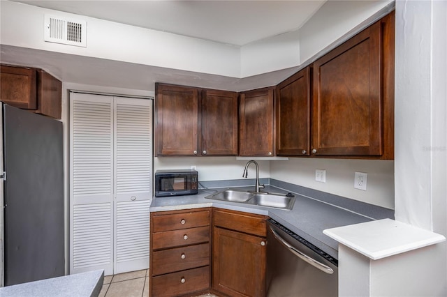 kitchen with light tile patterned flooring, appliances with stainless steel finishes, and sink