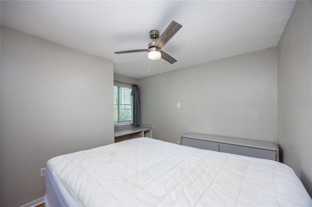 bedroom with ceiling fan and a textured ceiling