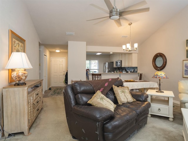 living room featuring lofted ceiling, light carpet, and ceiling fan with notable chandelier