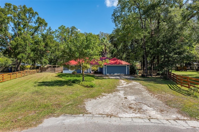 view of front of home with a front lawn, an outbuilding, and a garage