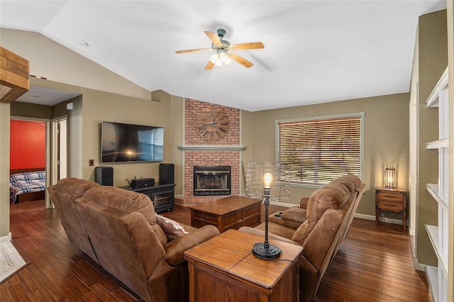 living room featuring lofted ceiling, ceiling fan, dark wood-type flooring, and a brick fireplace