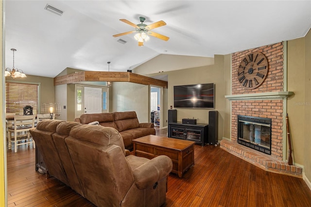 living room with ceiling fan with notable chandelier, a fireplace, lofted ceiling, and dark hardwood / wood-style floors