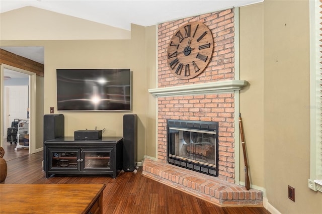 living room featuring vaulted ceiling, a fireplace, and dark hardwood / wood-style flooring