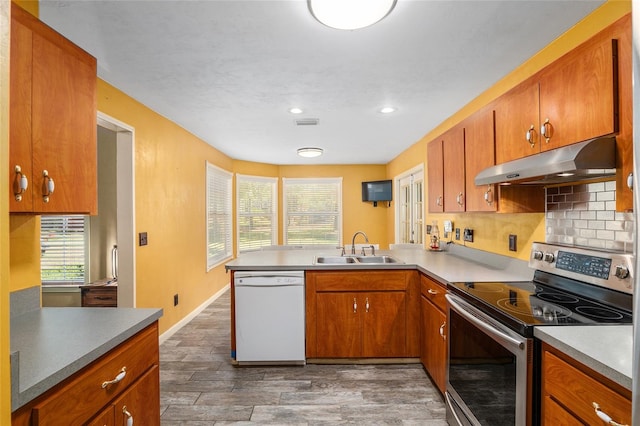 kitchen with dark hardwood / wood-style floors, stainless steel electric stove, kitchen peninsula, white dishwasher, and sink