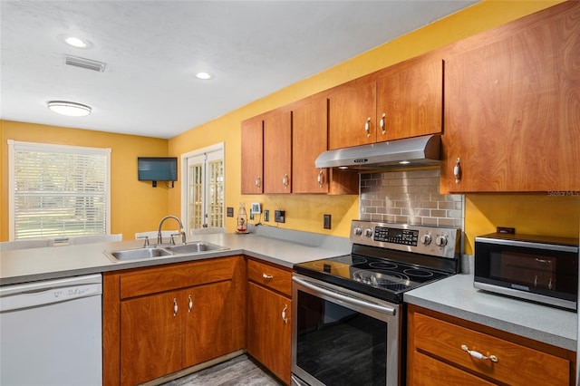 kitchen featuring sink, appliances with stainless steel finishes, light wood-type flooring, and tasteful backsplash