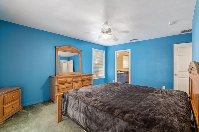 bedroom featuring ceiling fan, light carpet, and ensuite bath