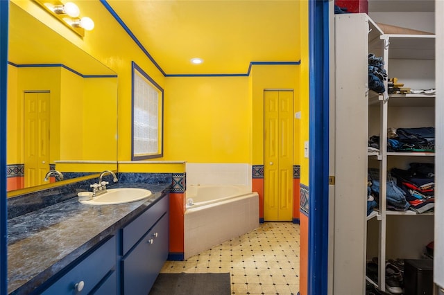 bathroom with vanity and tiled bath