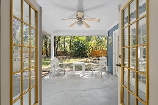 unfurnished sunroom featuring ceiling fan