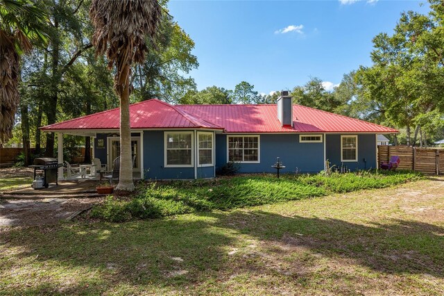 rear view of house featuring a yard