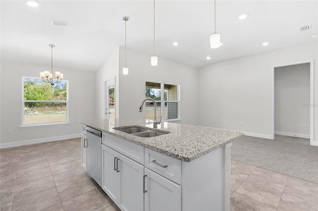 kitchen with a wealth of natural light, stainless steel dishwasher, sink, and a kitchen island with sink