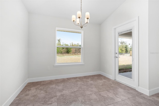 empty room with vaulted ceiling, a notable chandelier, a wealth of natural light, and light tile patterned flooring