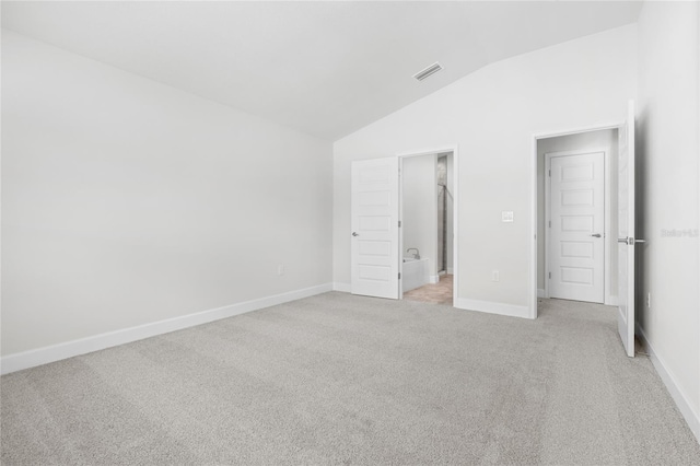 unfurnished bedroom with light colored carpet and vaulted ceiling