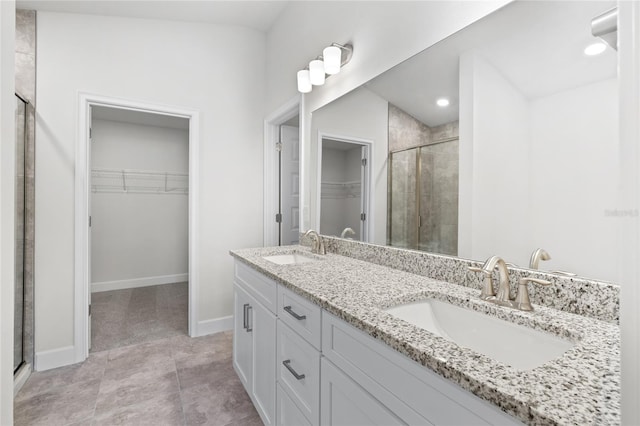 bathroom featuring vanity, a shower with shower door, and tile patterned flooring