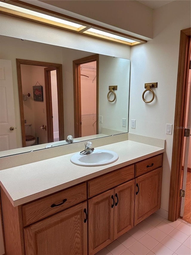 bathroom featuring toilet, vanity, and tile patterned floors