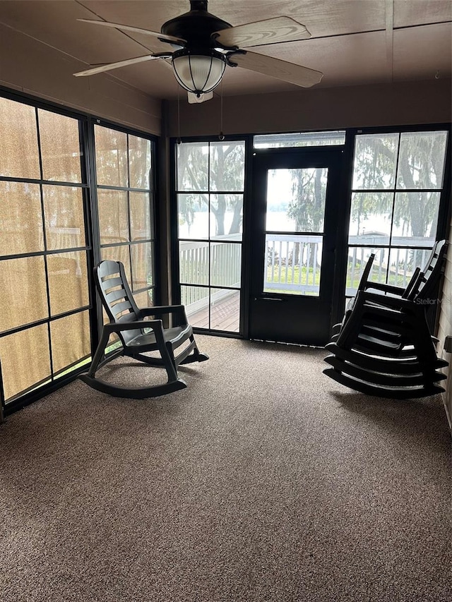 unfurnished sunroom with ceiling fan