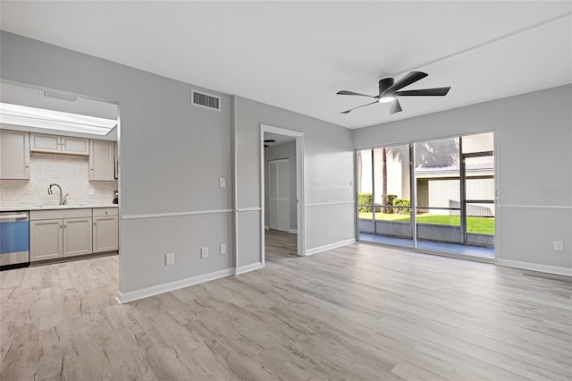 unfurnished living room with ceiling fan, sink, and light wood-type flooring