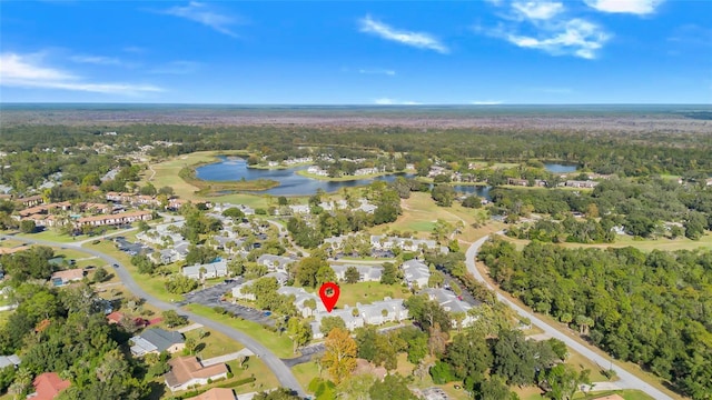 drone / aerial view featuring a residential view, golf course view, a water view, and a forest view