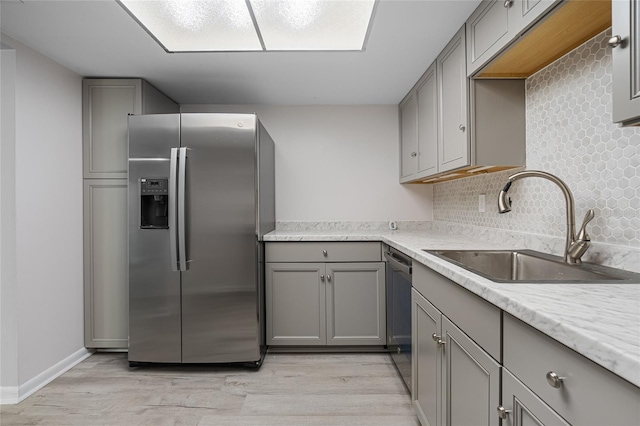 kitchen featuring light hardwood / wood-style floors, tasteful backsplash, stainless steel appliances, and sink