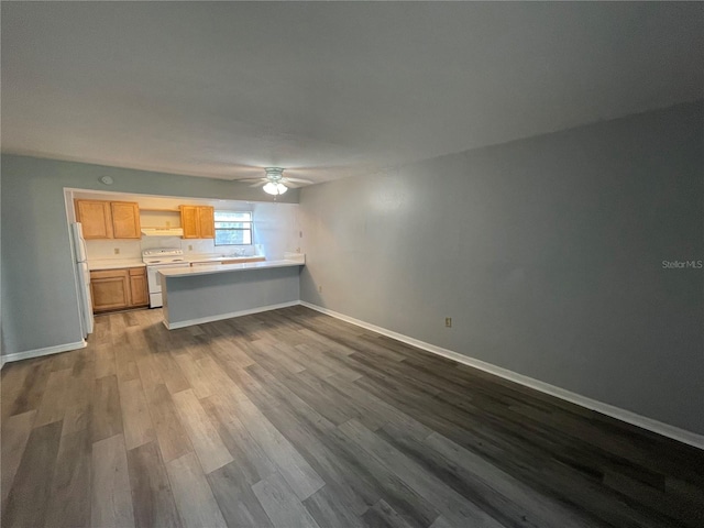 unfurnished living room with ceiling fan and wood-type flooring