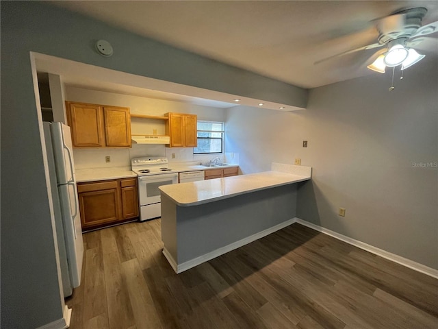 kitchen featuring kitchen peninsula, wood-type flooring, sink, white appliances, and ceiling fan