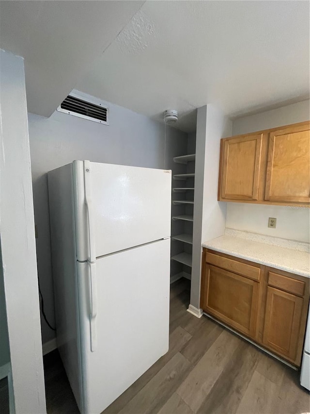 kitchen with hardwood / wood-style floors and white refrigerator