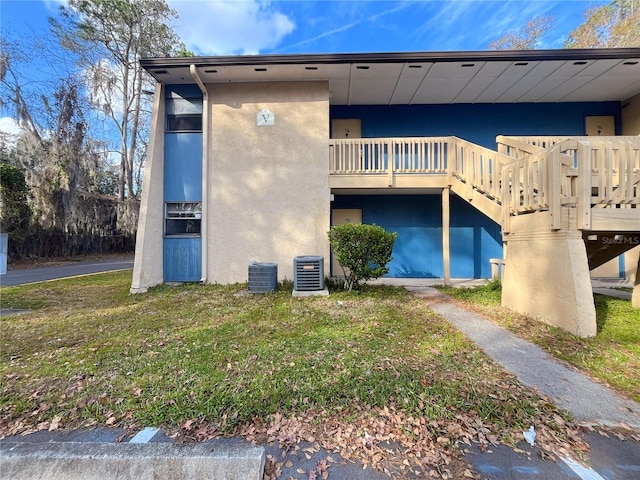 back of house featuring a balcony, a yard, and cooling unit