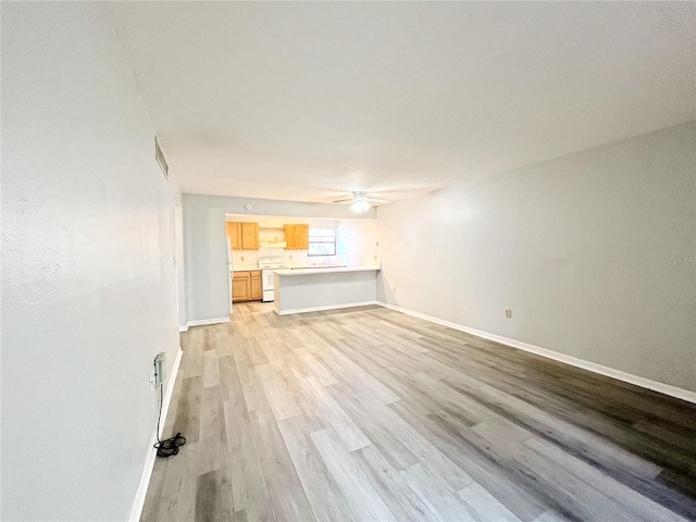 unfurnished living room featuring ceiling fan and light hardwood / wood-style flooring