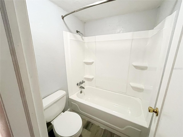 bathroom with toilet, tub / shower combination, and hardwood / wood-style floors