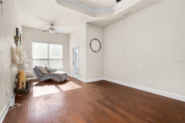 unfurnished room with dark wood-type flooring, a tray ceiling, and ceiling fan