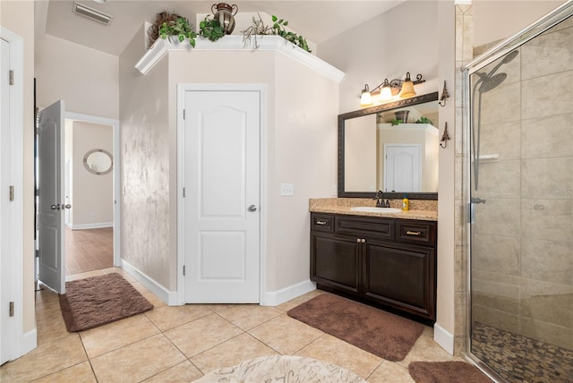 bathroom featuring vanity, a shower with shower door, and tile patterned flooring