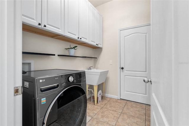 clothes washing area featuring washer / dryer, light tile patterned floors, and cabinets