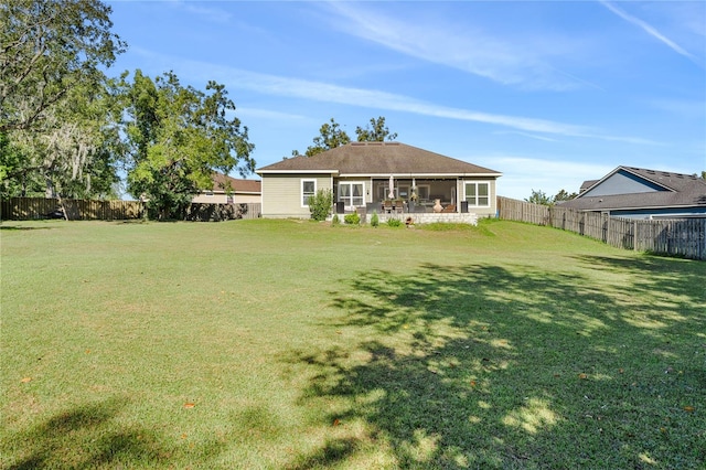 rear view of house with a sunroom and a lawn