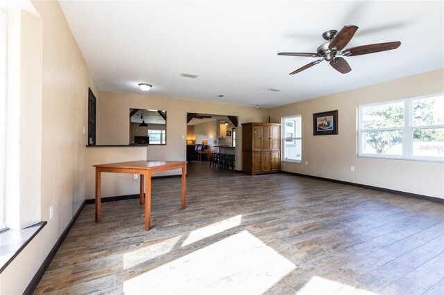 unfurnished living room with dark wood-type flooring and ceiling fan