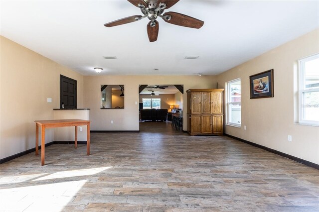 unfurnished living room featuring ceiling fan and wood-type flooring